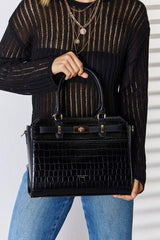 a woman holding a black handbag in her right hand