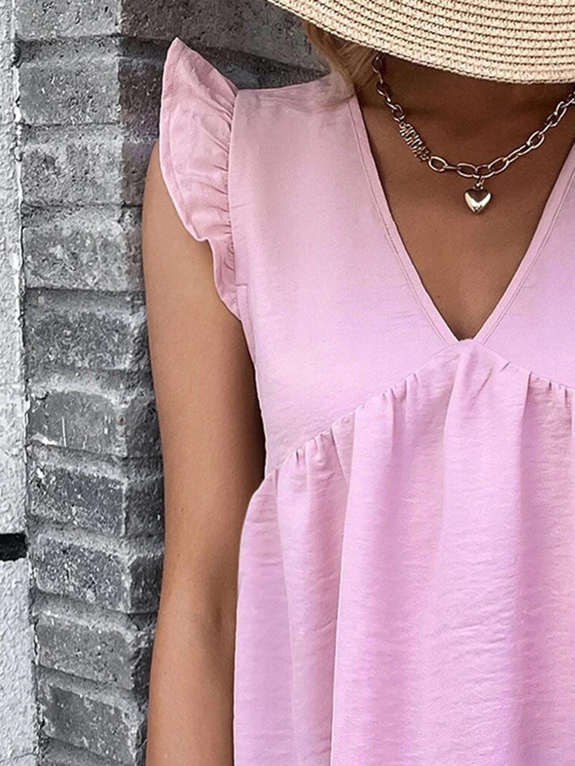 a woman wearing a pink top and a straw hat