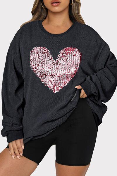 a woman wearing a black sweatshirt with a heart on it