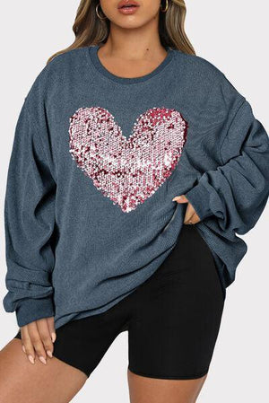 a woman wearing a blue sweater with a heart on it