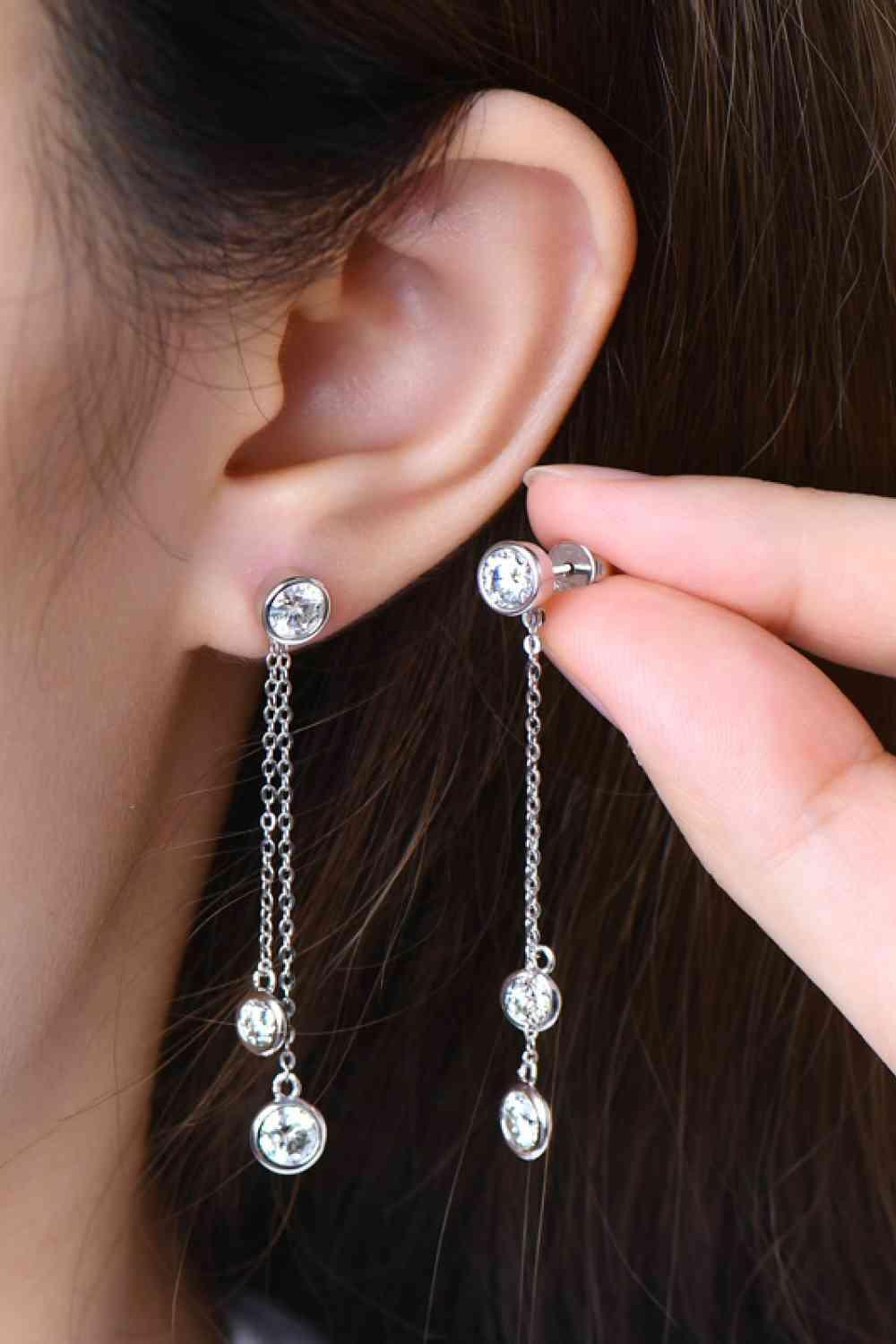 a close up of a person wearing a pair of earrings