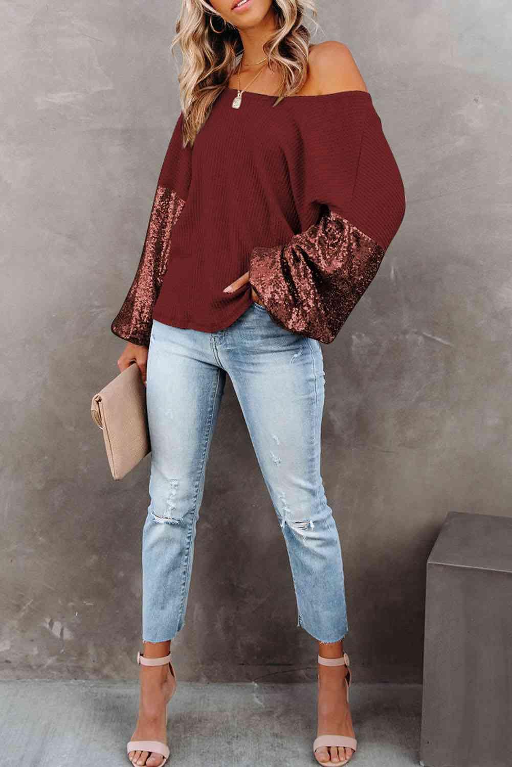 a woman wearing a burgundy top and jeans