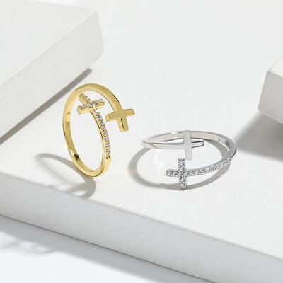 two rings with a cross on them sitting on a white surface