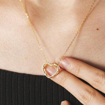 a close up of a person holding a heart necklace