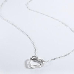 a silver heart necklace on a white background