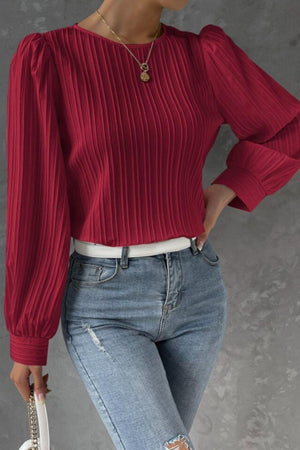a woman wearing ripped jeans and a red top