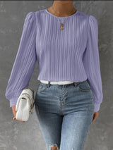 a woman wearing a purple top and ripped jeans