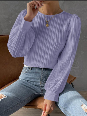 a woman wearing a purple sweater and ripped jeans