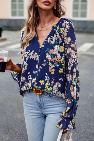 a woman wearing a blue floral blouse and jeans