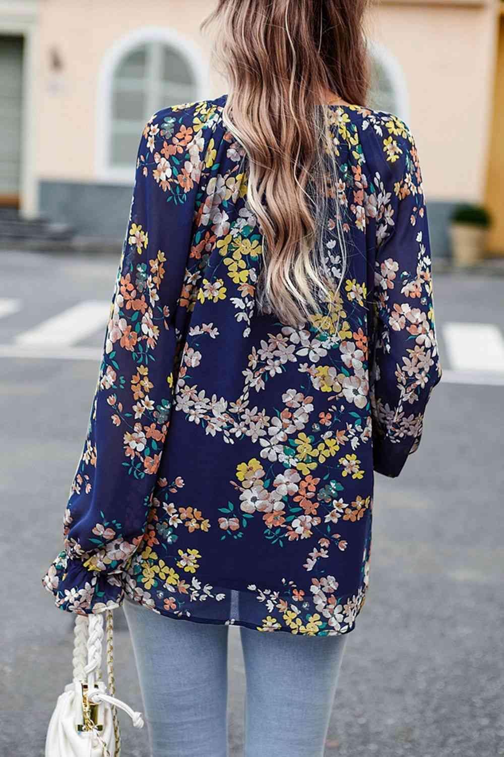 a woman wearing a floral blouse and jeans