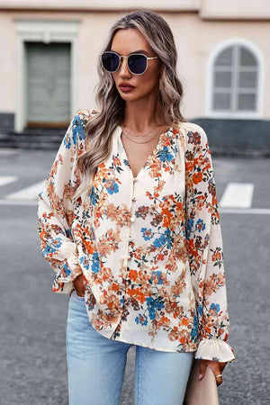 a woman wearing a floral blouse and jeans