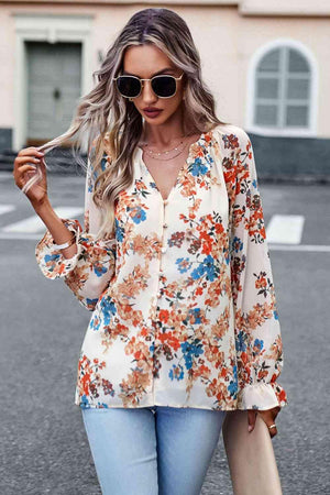 a woman wearing a floral blouse and jeans