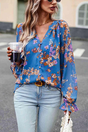 a woman wearing a blue floral blouse and jeans