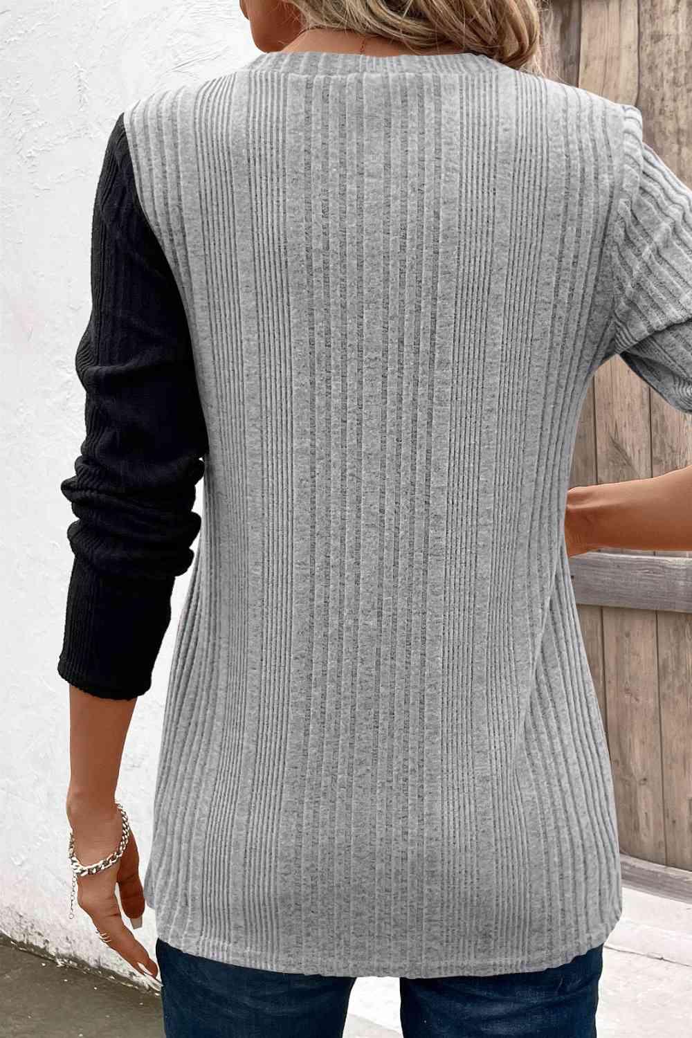 a woman wearing a gray sweater and jeans