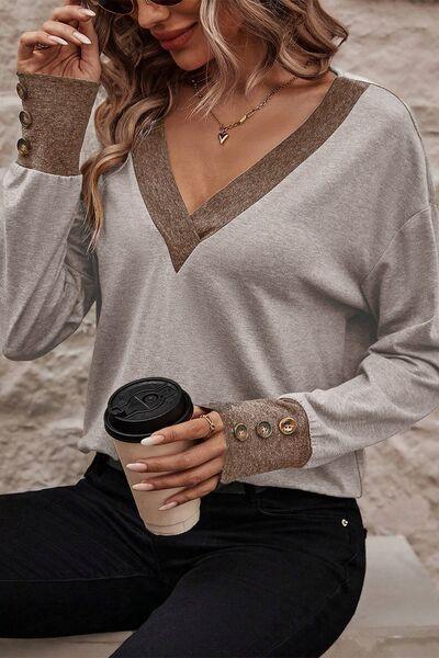 a woman sitting on a ledge holding a cup of coffee