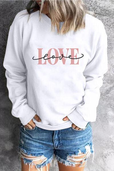 a woman wearing a white sweatshirt with the word love on it