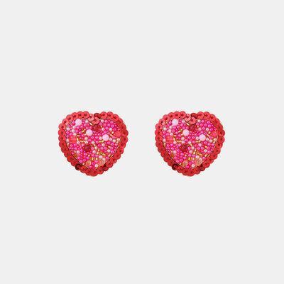 a pair of red heart shaped earrings on a white background
