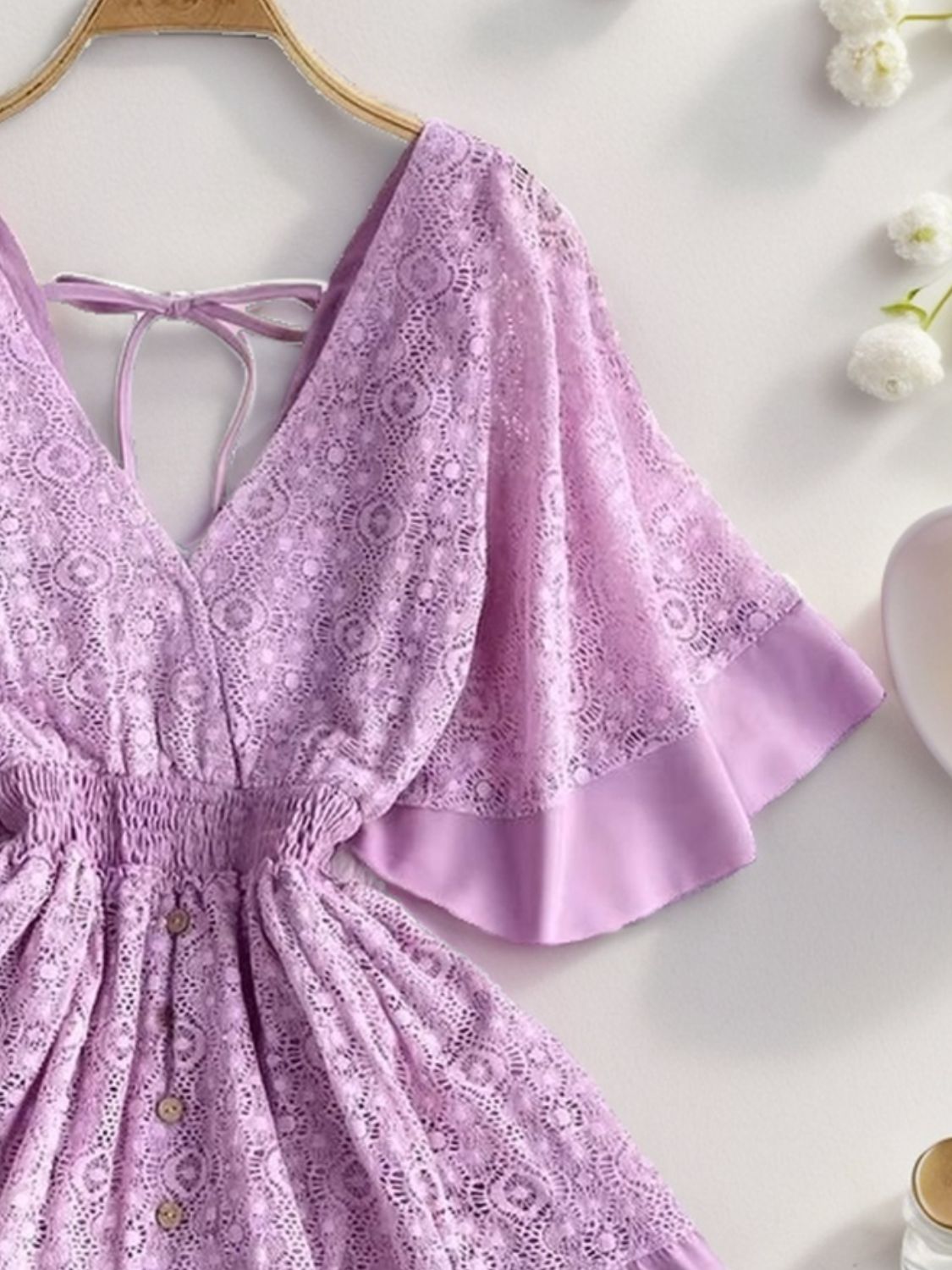 a woman's purple dress on a hanger next to a cup of coffee