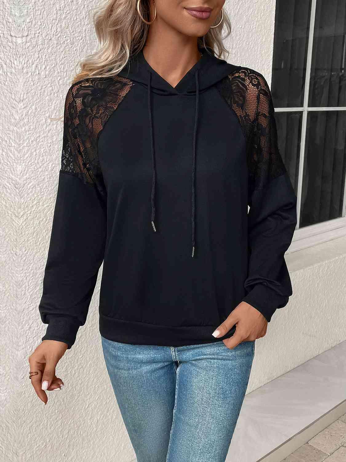 a woman wearing a black hoodie and jeans