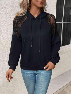 a woman wearing a black hoodie and jeans