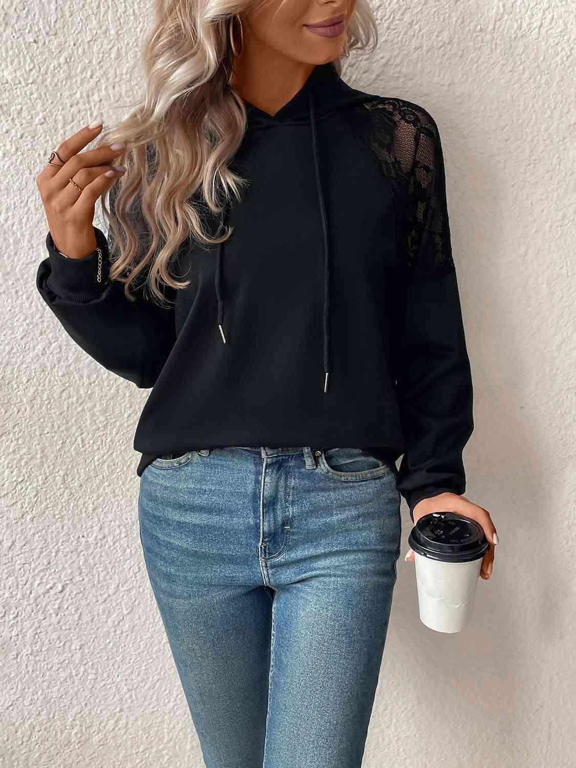 a woman wearing a black hoodie and jeans