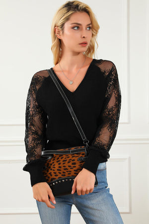 a woman in a black top holding a leopard print purse