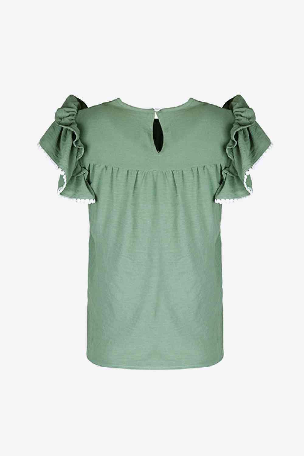 a green top with ruffles on the shoulders