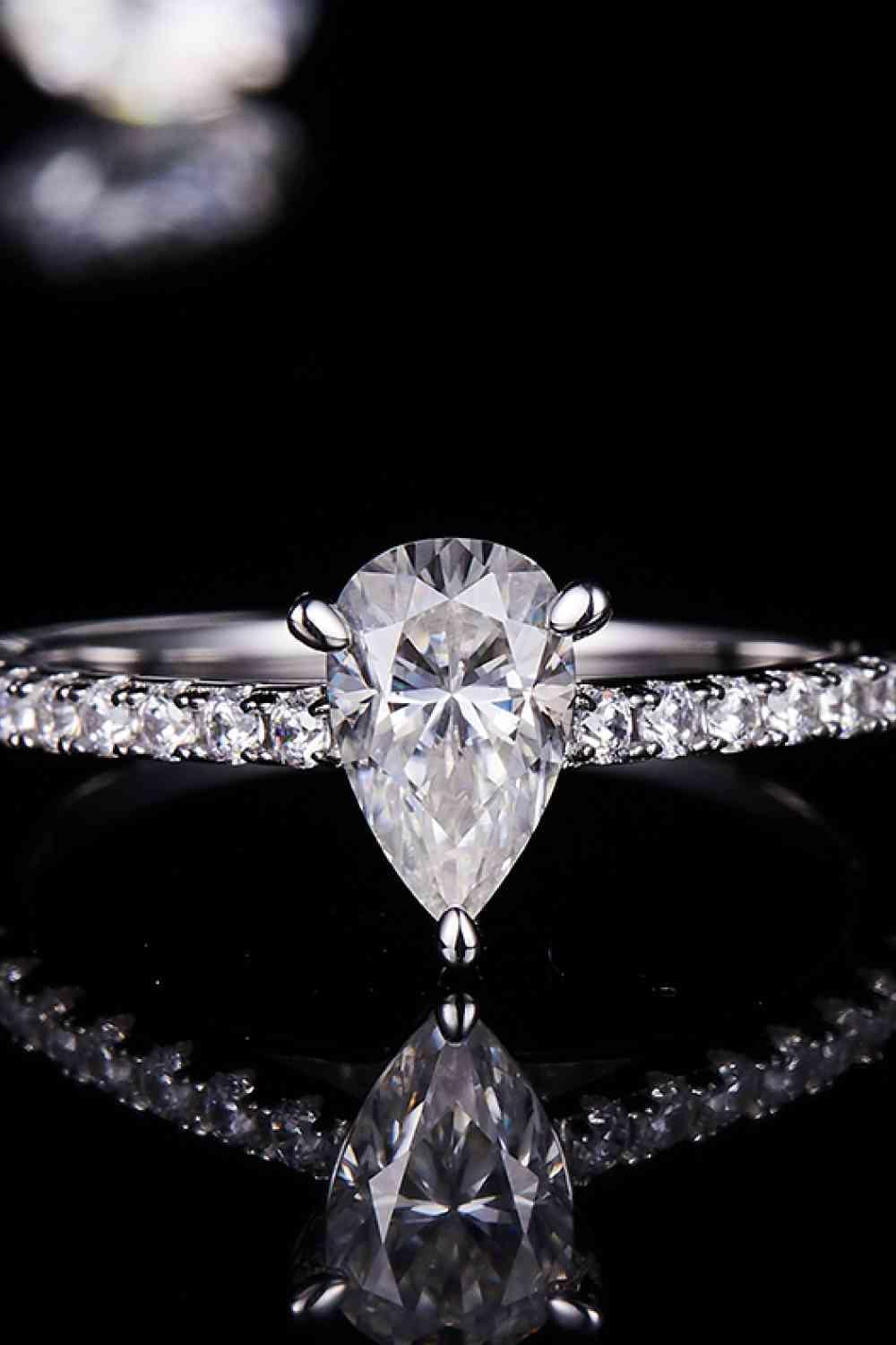 a close up of a diamond ring on a black surface