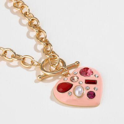 a pink heart shaped keychain with a red heart on it