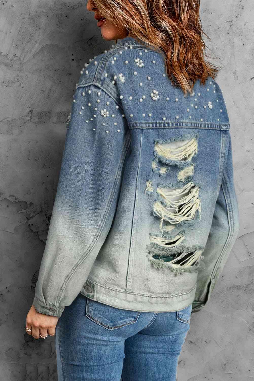 a woman wearing a denim jacket with studded details
