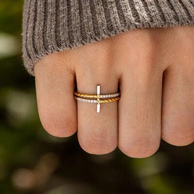 a woman's hand with a cross ring on it