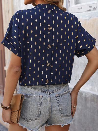 a woman wearing a blue shirt and denim shorts