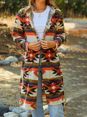 a woman standing on a dirt road wearing a colorful cardigan