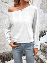 a woman wearing a white sweater and jeans