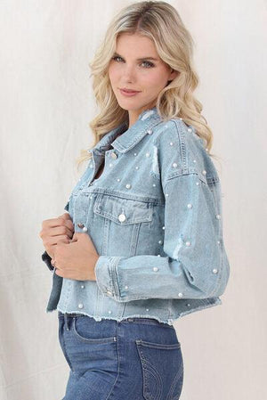 a woman in a jean jacket posing for a picture
