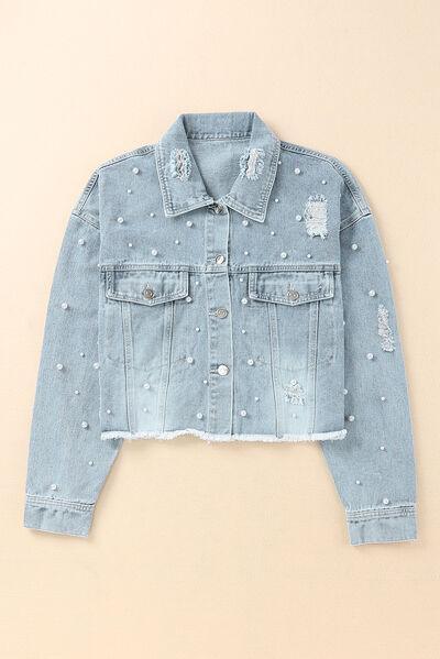 a denim jacket with holes and pearls on it