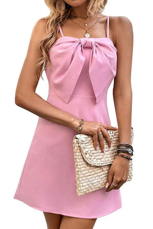 a woman in a pink dress holding a white purse