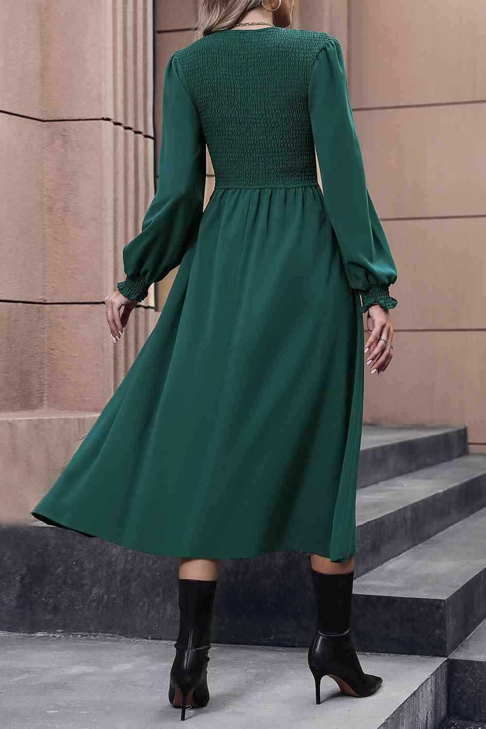 a woman wearing a green dress and black boots