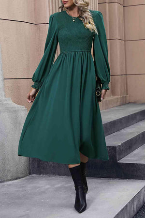 a woman wearing a green dress and black boots
