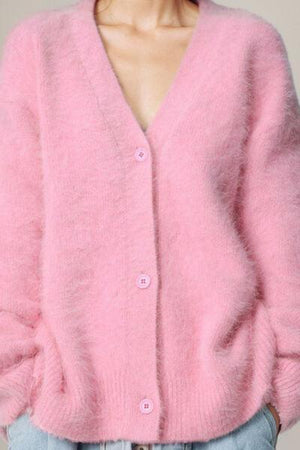 a woman wearing a pink fuzzy cardigan sweater