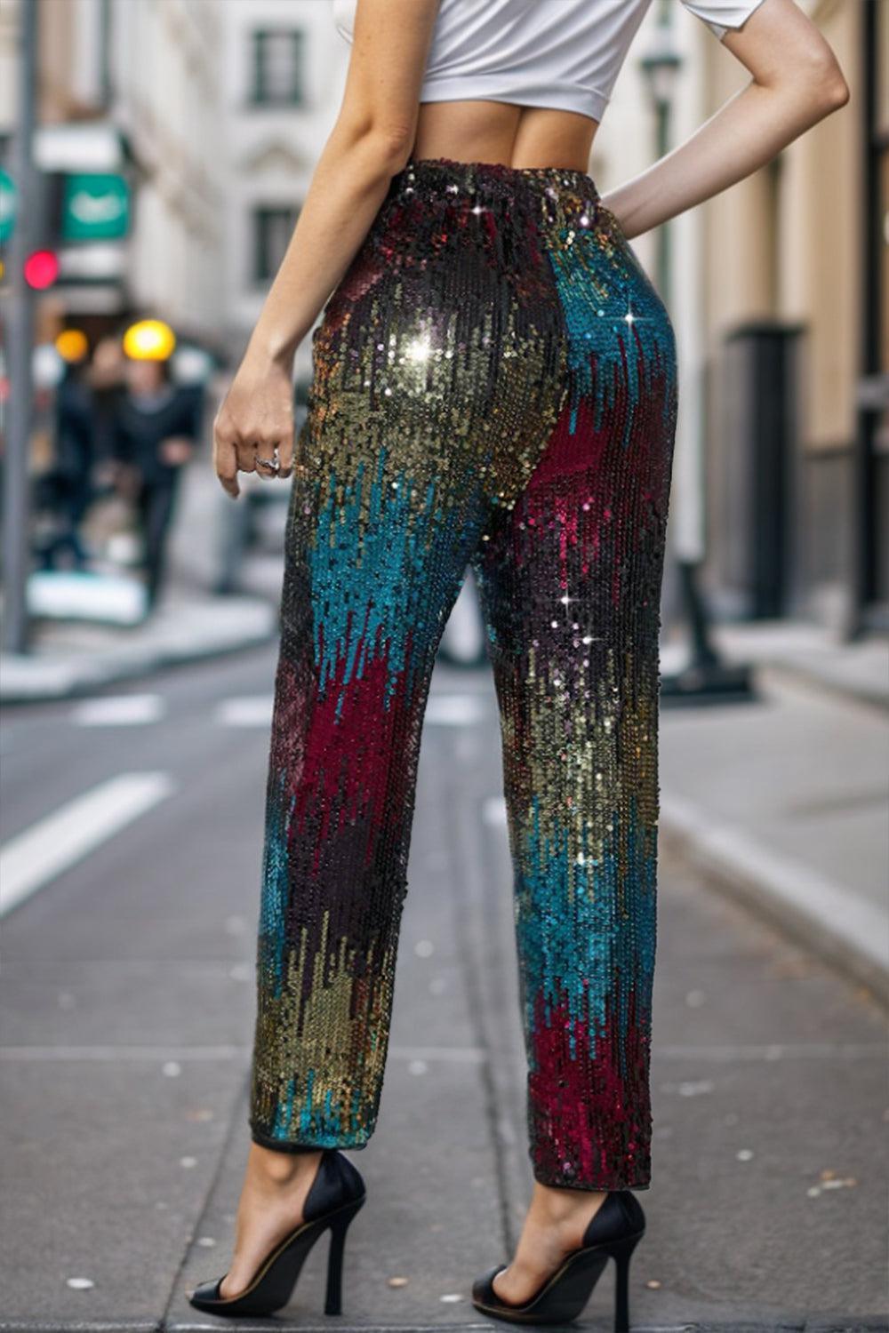 a woman standing on a city street wearing sequin pants