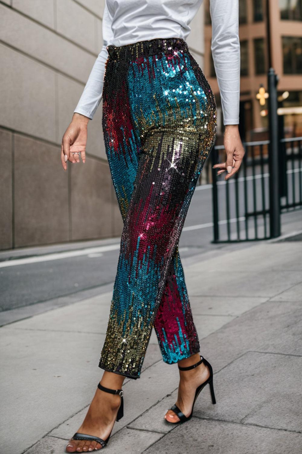 a woman in a white shirt and colorful sequin pants