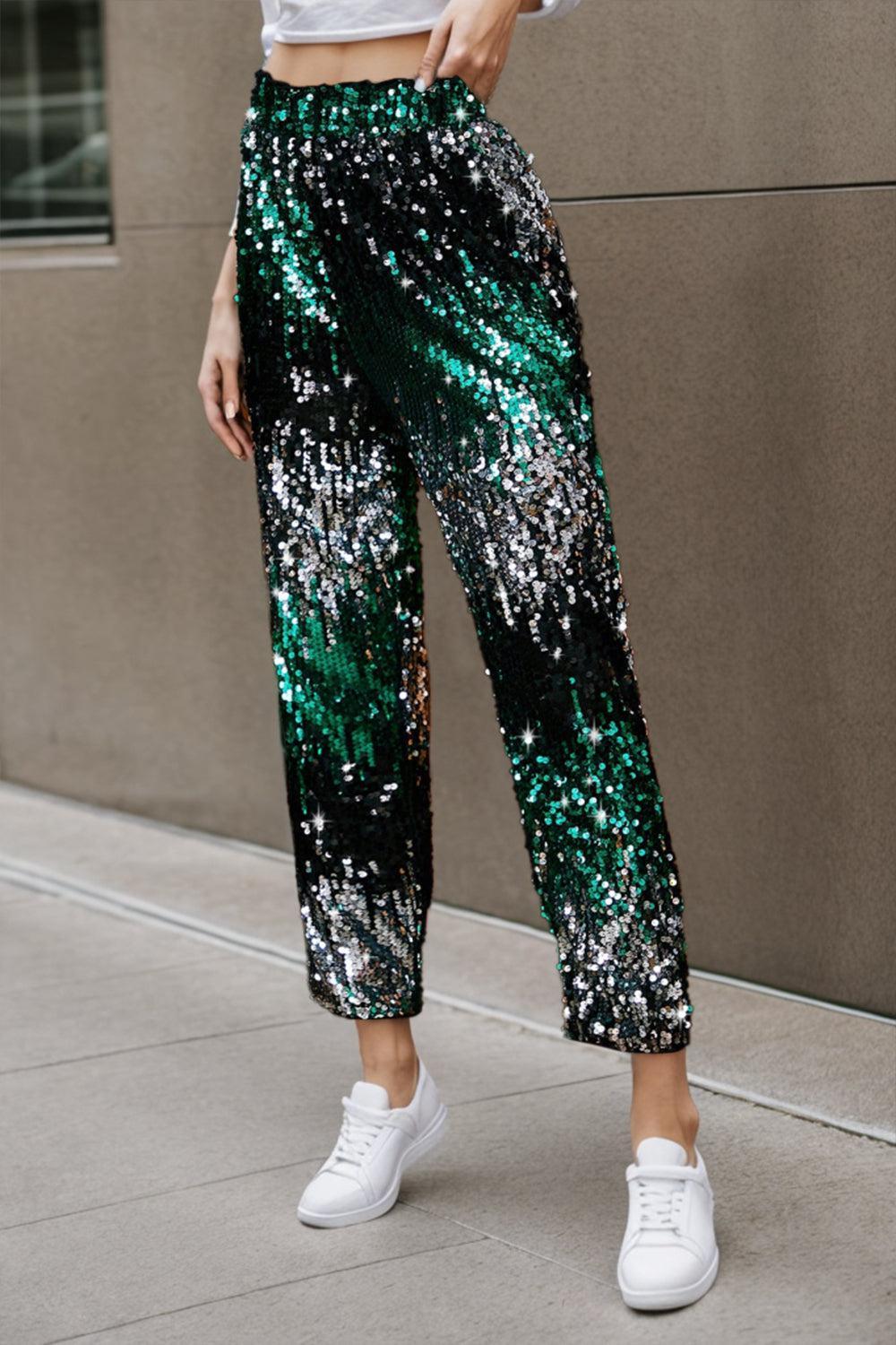 a woman in a white top and green sequin pants