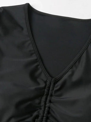 a close up of a black top on a white surface