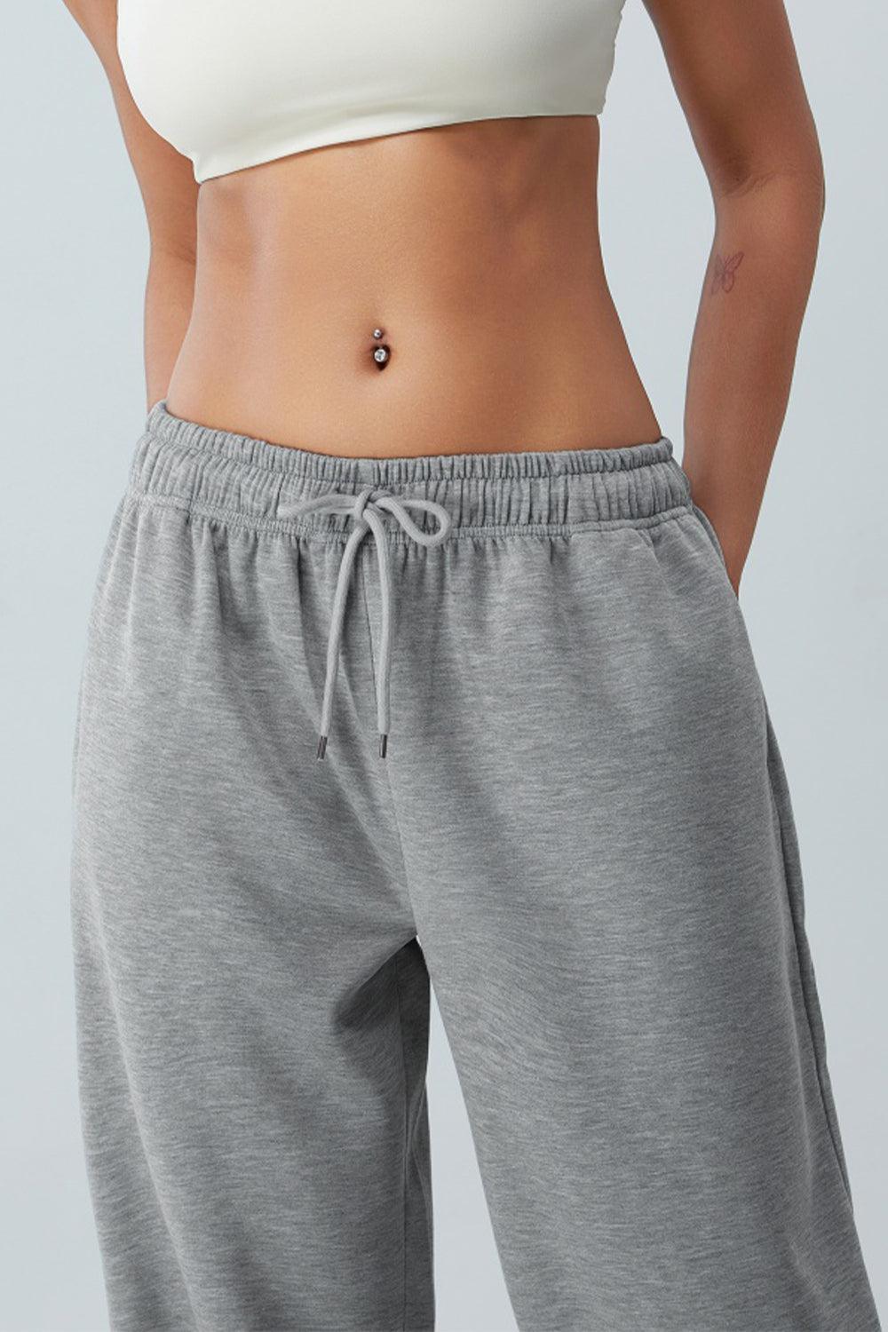 a woman in grey sweat pants and a white top