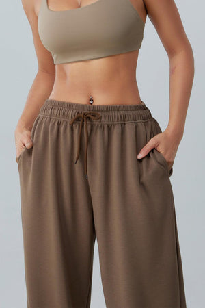 a woman in a tan bra top and brown pants