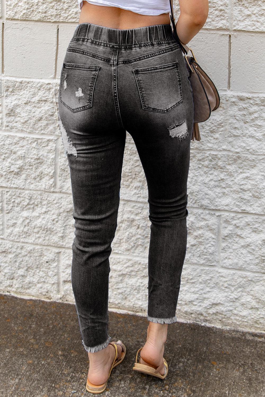 a woman in a white tank top and black jeans