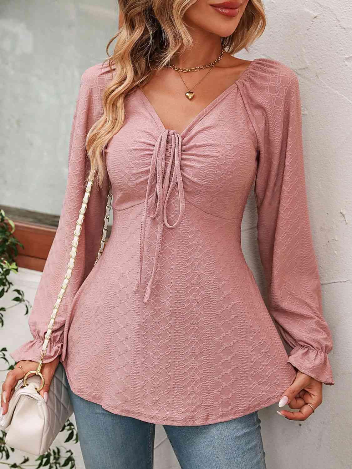 a woman wearing a pink top and jeans