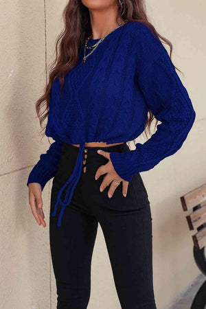 a woman wearing a blue sweater and black pants