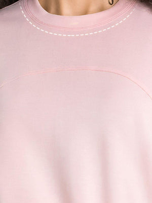 a close up of a person wearing a pink shirt